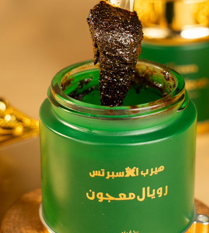 A spoonful of dark Royal Majoon lifted from the jar