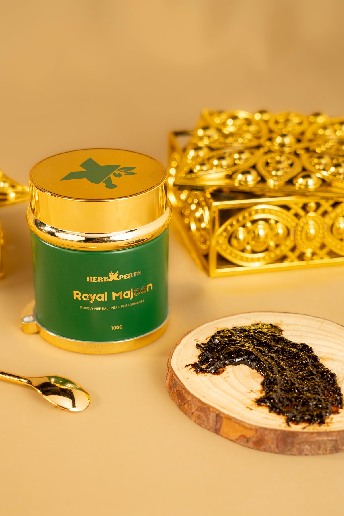 Royal Majoon on a wooden board beside the jar and its gold spoon